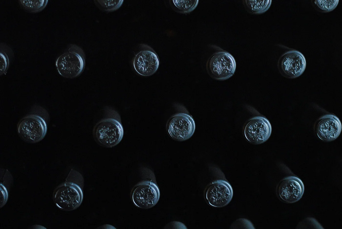 Bottles resting neck-down in a riddling rack